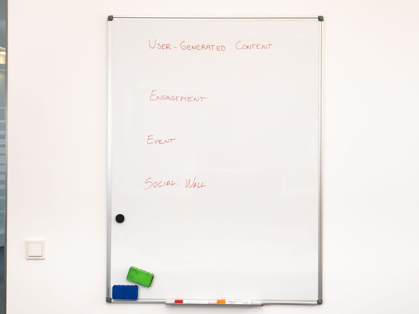 A whiteboard with a short plan written out in marker, the steps laid down one under the next